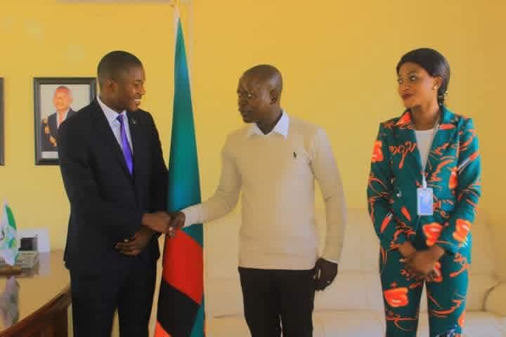 PIC Zambia national coordinator in a formal meeting at a government office with the Zambia national flag